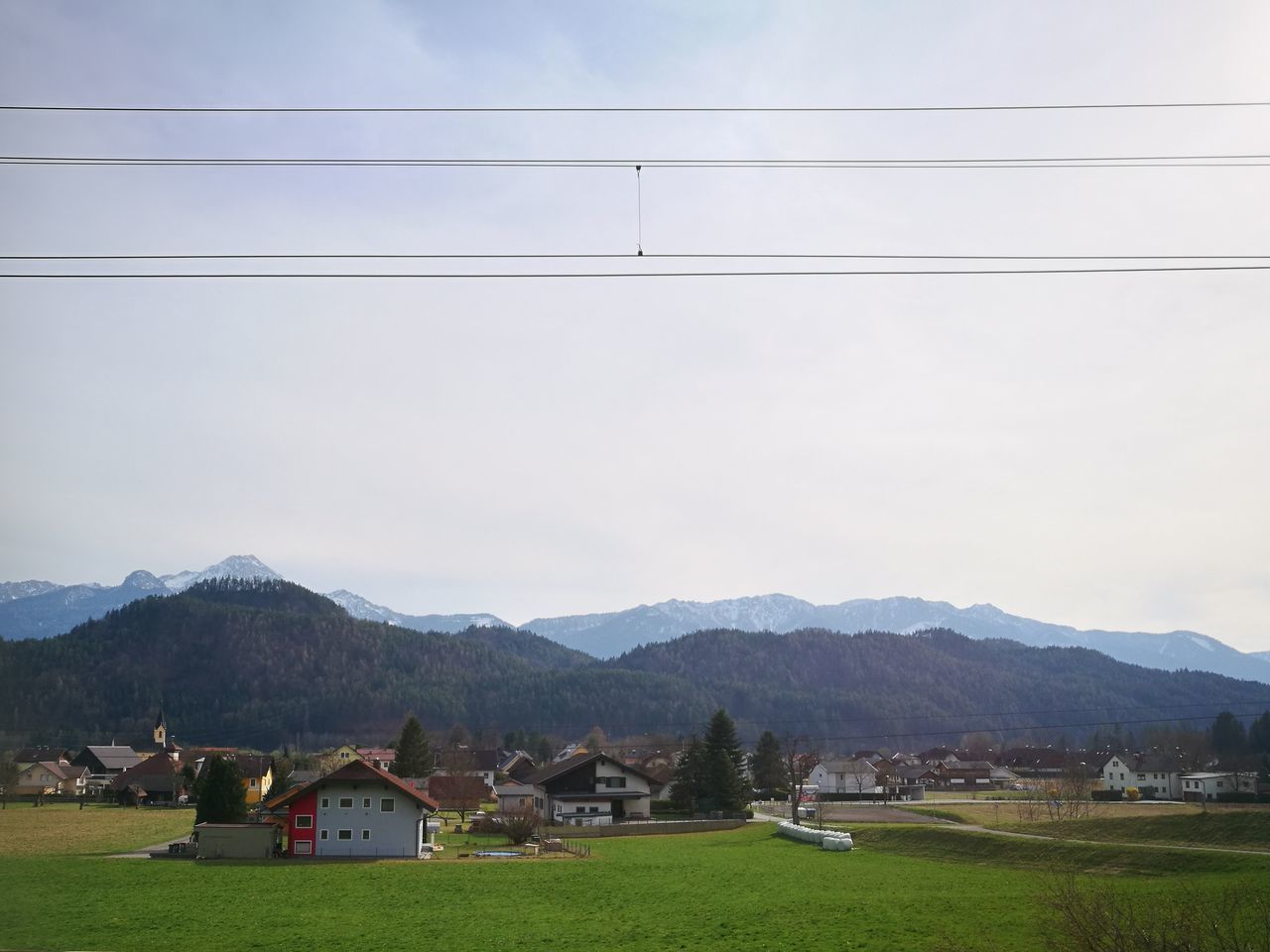 HOUSES ON LANDSCAPE AGAINST MOUNTAINS