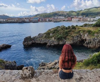 Rear view of woman looking at sea against sky