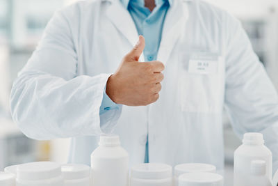 Midsection of scientist holding medicine in laboratory