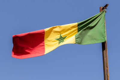 Low angle view of senegalese flag against clear blue sky