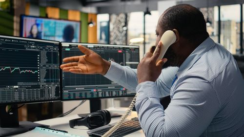 Rear view of man using mobile phone in office