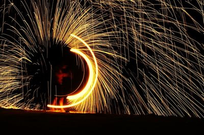 Man spinning wire wool at night