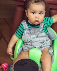 Cute baby boy sitting in bedroom
