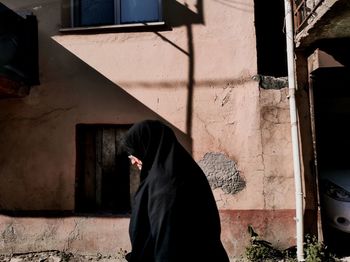 Man standing by window in abandoned building
