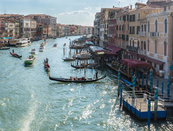 High angle view of boats in canal amidst buildings in city