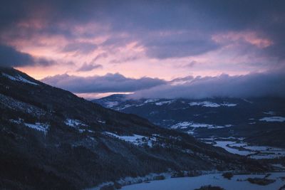 Snow covered mountains against cloudy sky