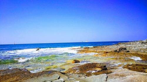 Scenic view of sea against clear blue sky