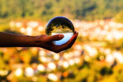Close-up of hand holding crystal ball