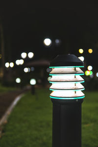 Close-up of illuminated light bulb on field