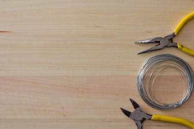 Directly above shot of pliers and steel cable on table