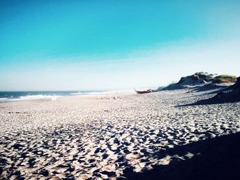 Scenic view of beach against clear blue sky