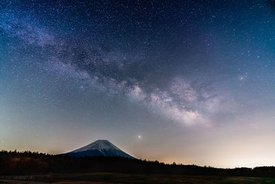 Scenic view of mountains against sky at night