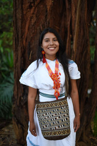 Portrait of a happy young arhuaco indigenous woman in a forest of colombia