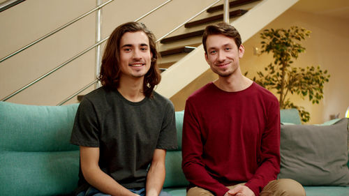 Portrait homosexual couple sitting at home