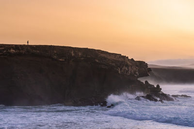 Lonely silhouette on costal rocks