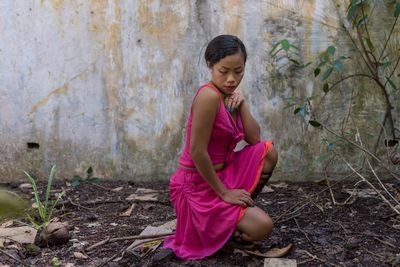 Young woman wearing pink dress on land