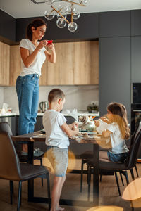 Happy young woman with hands on table at home