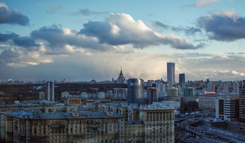 View of cityscape against cloudy sky