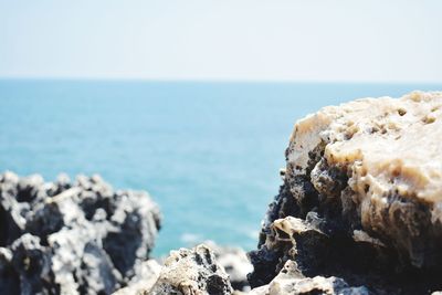 Rocks on beach against clear sky