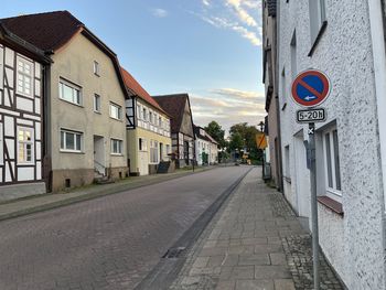 Road amidst buildings against sky