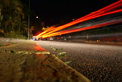 Close-up of illuminated road against sky at night