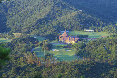 High angle view of building and trees by mountain