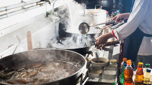 Man working on barbecue grill in kitchen