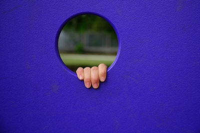 Person hand on purple wall