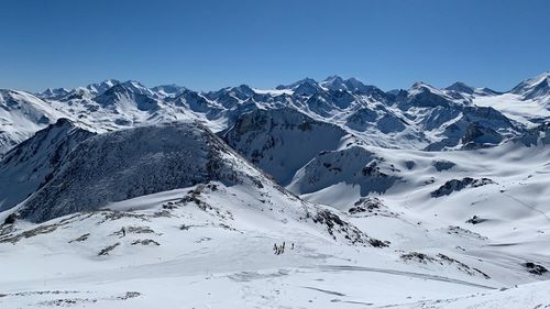 Scenic view of snowcapped mountains against clear blue sky