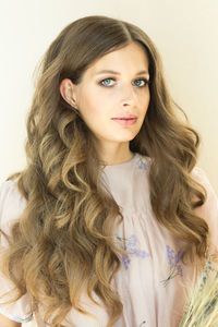 Portrait of young woman against white background