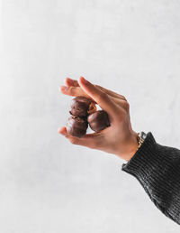 Close-up of hand holding food against white background