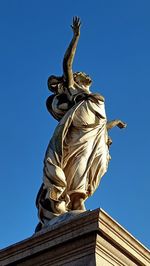 Low angle view of statue against blue sky