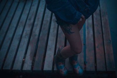 Low section of woman standing on boardwalk