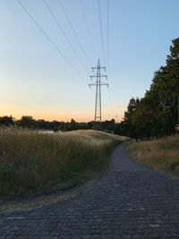 Road on field against sky during sunset