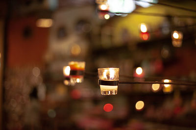Close-up of illuminated lit candle in city at night