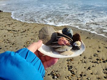 Midsection of person holding ice cream on beach