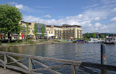 River by buildings in city against sky