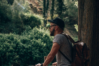 Side view of young man in forest