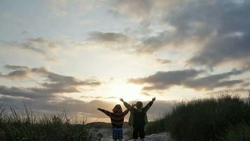 Silhouette of people against cloudy sky