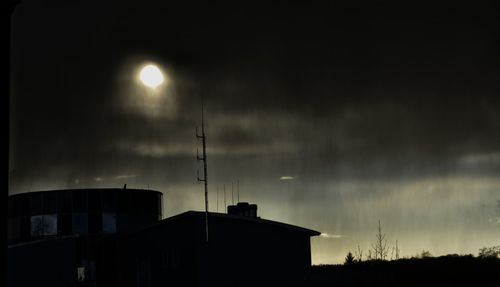 Low angle view of silhouette buildings against sky at night