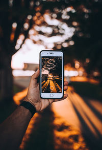 Close-up of hand holding smart phone at night