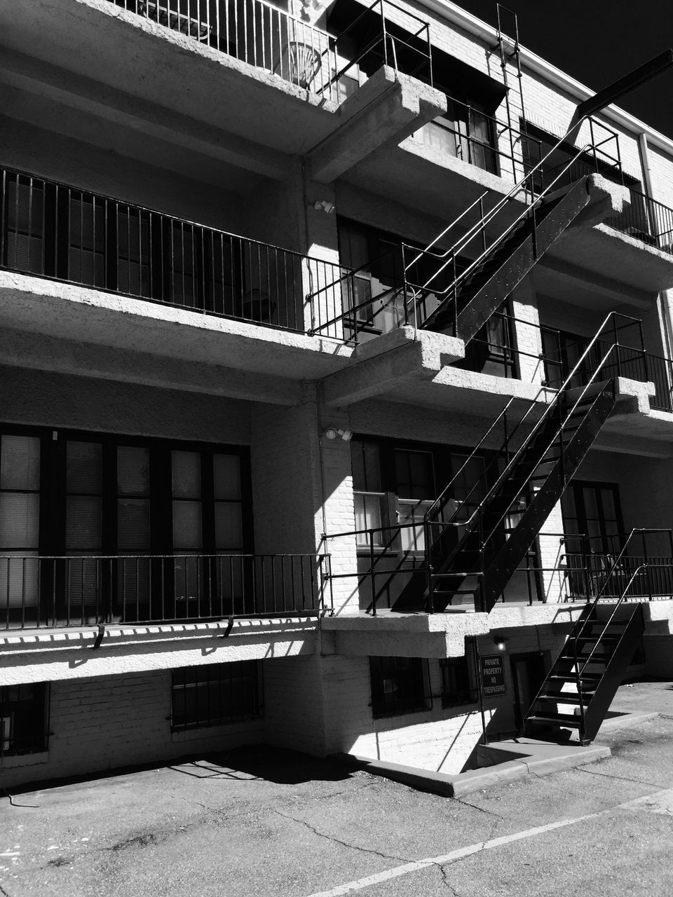 architecture, built structure, building exterior, railing, sunlight, day, no people, empty, building, residential building, roof, outdoors, chair, in a row, absence, residential structure, balcony, metal, city, shadow