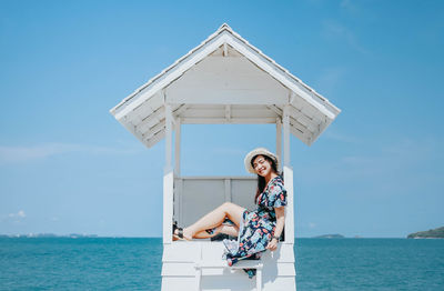 Woman by sea against blue sky