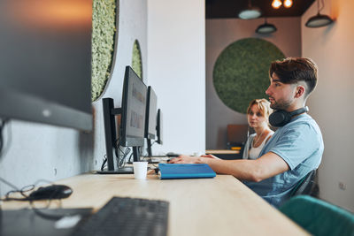 Students learning in computer classroom. young man preparing for test on computer