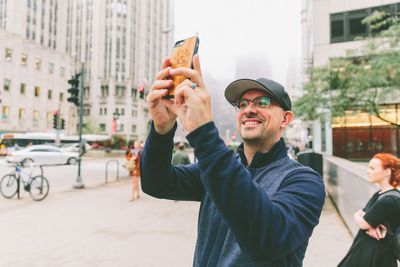 Portrait of young man using smart phone in city