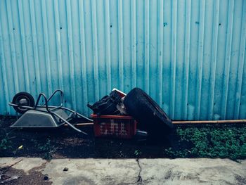 Abandoned garbage can on land against wall