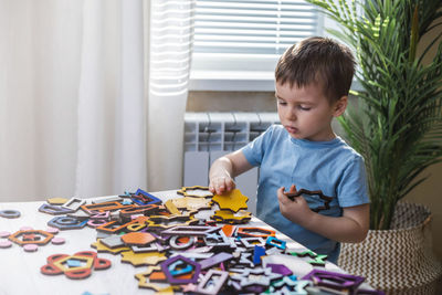 Boy playing with toys on table at home