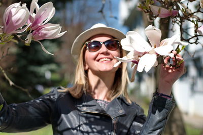 Portrait of young woman with magnolia blooming