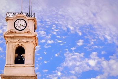 Low angle view of clock tower against blue sky