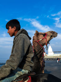 Side view of boy in sea against sky